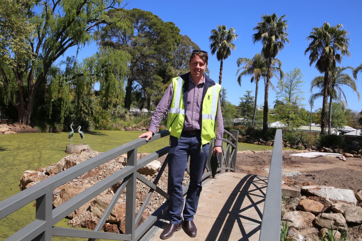 Male Project officer standing on garden bridge