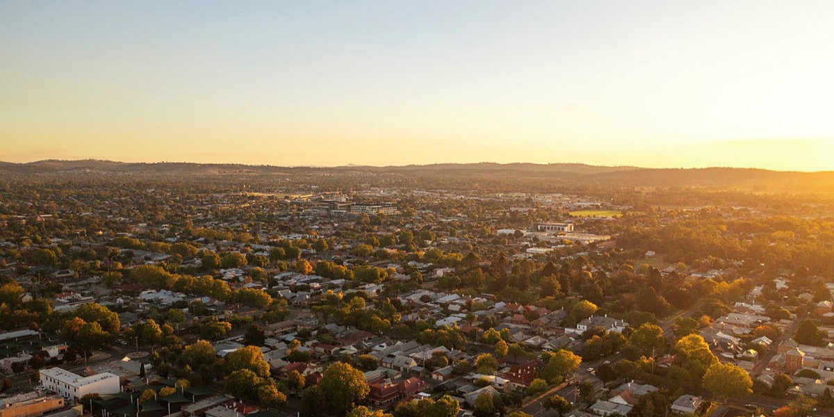 A drone image of Wagga Wagga, looking across to the horizon at dusk. 