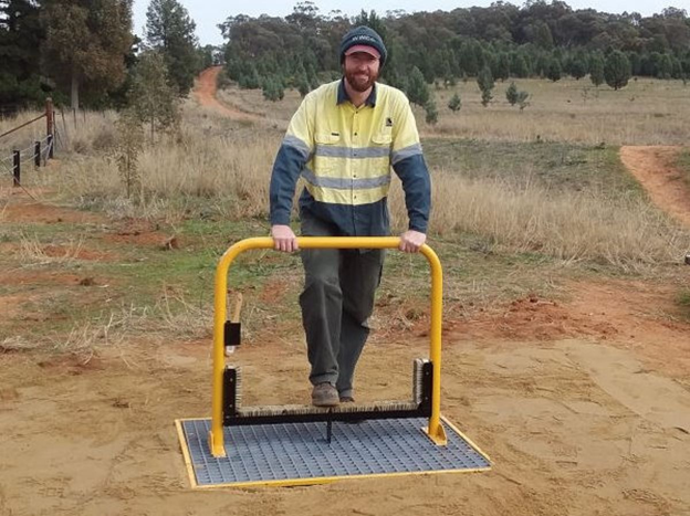 A man in high vis clothing standing at a weed hygiene station