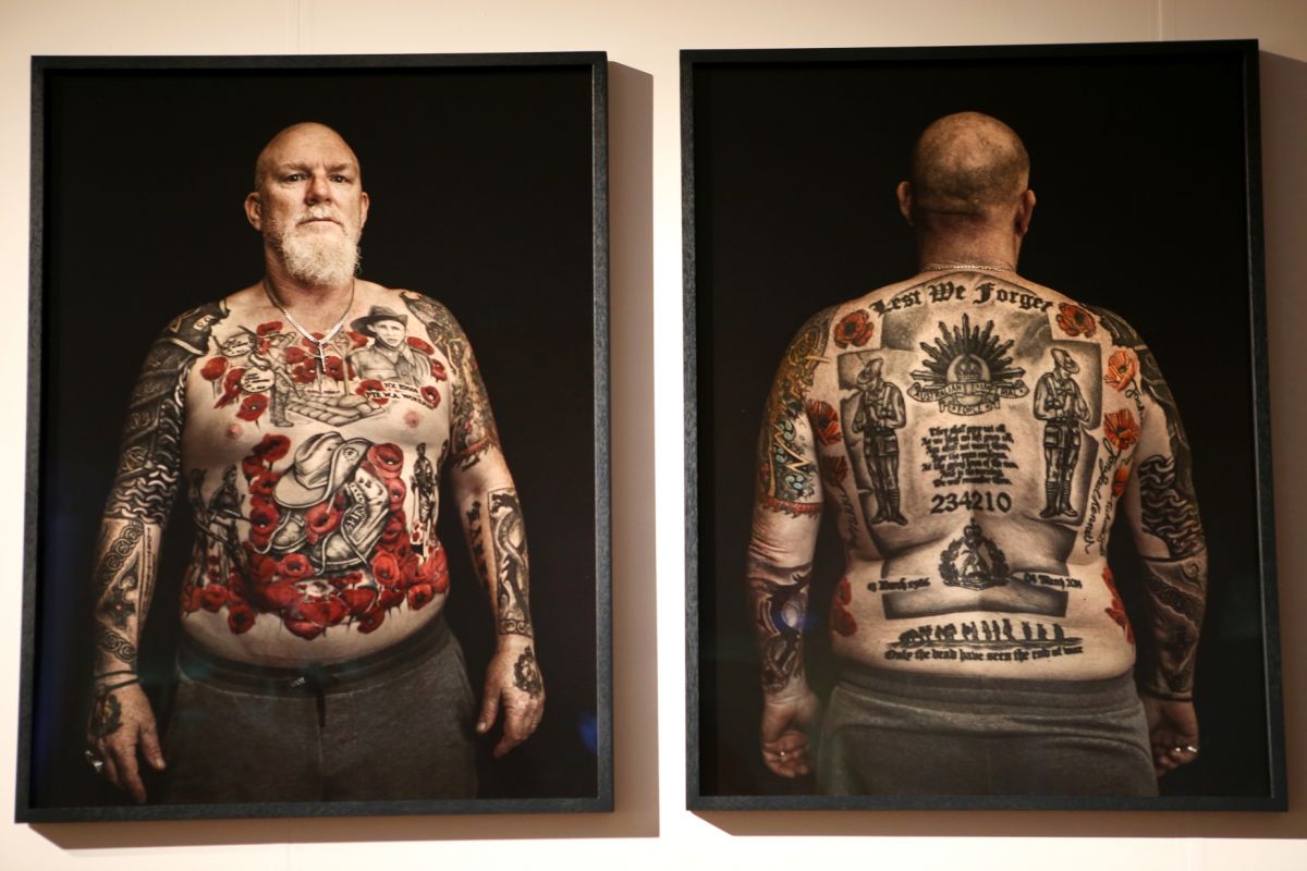 portrait of bearded man with tattoos on gallery wall
