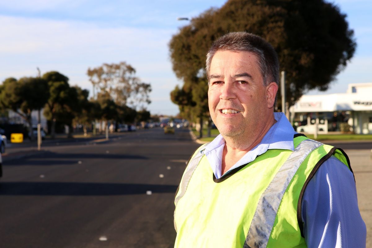 Man facing camera with freshly rehabilitated road in background