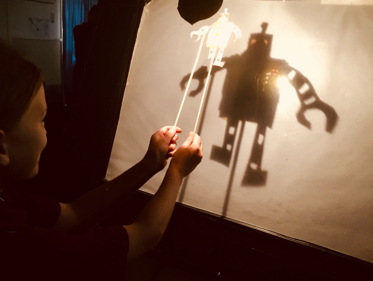 child performing with shadow puppet