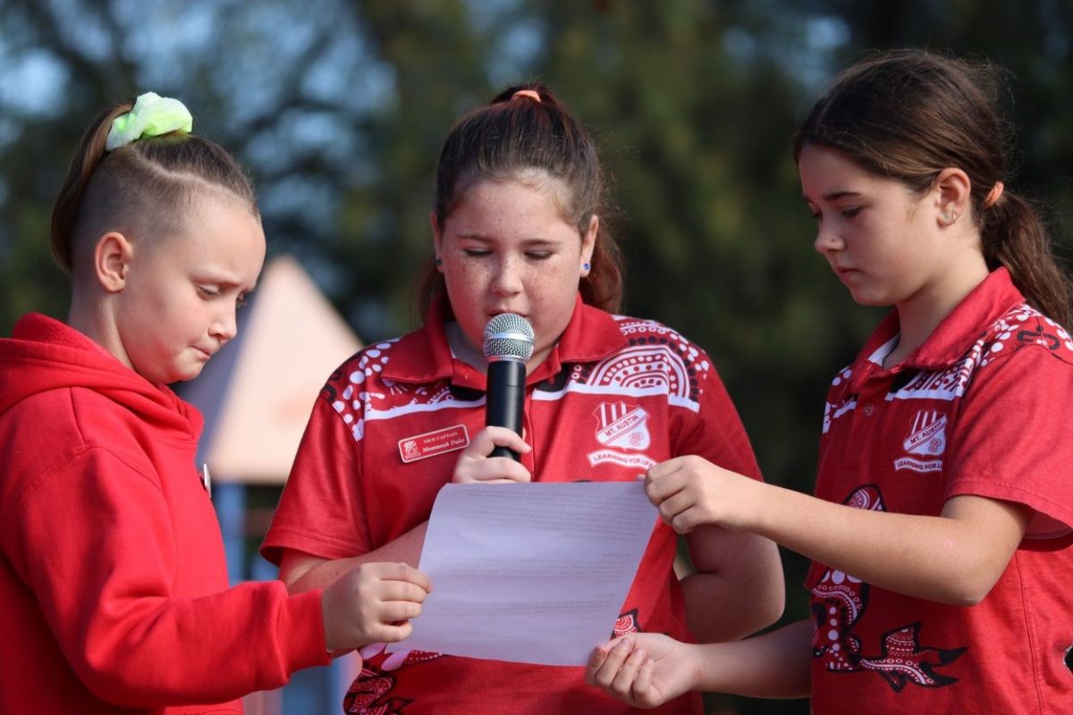 Three young people saying a speech.